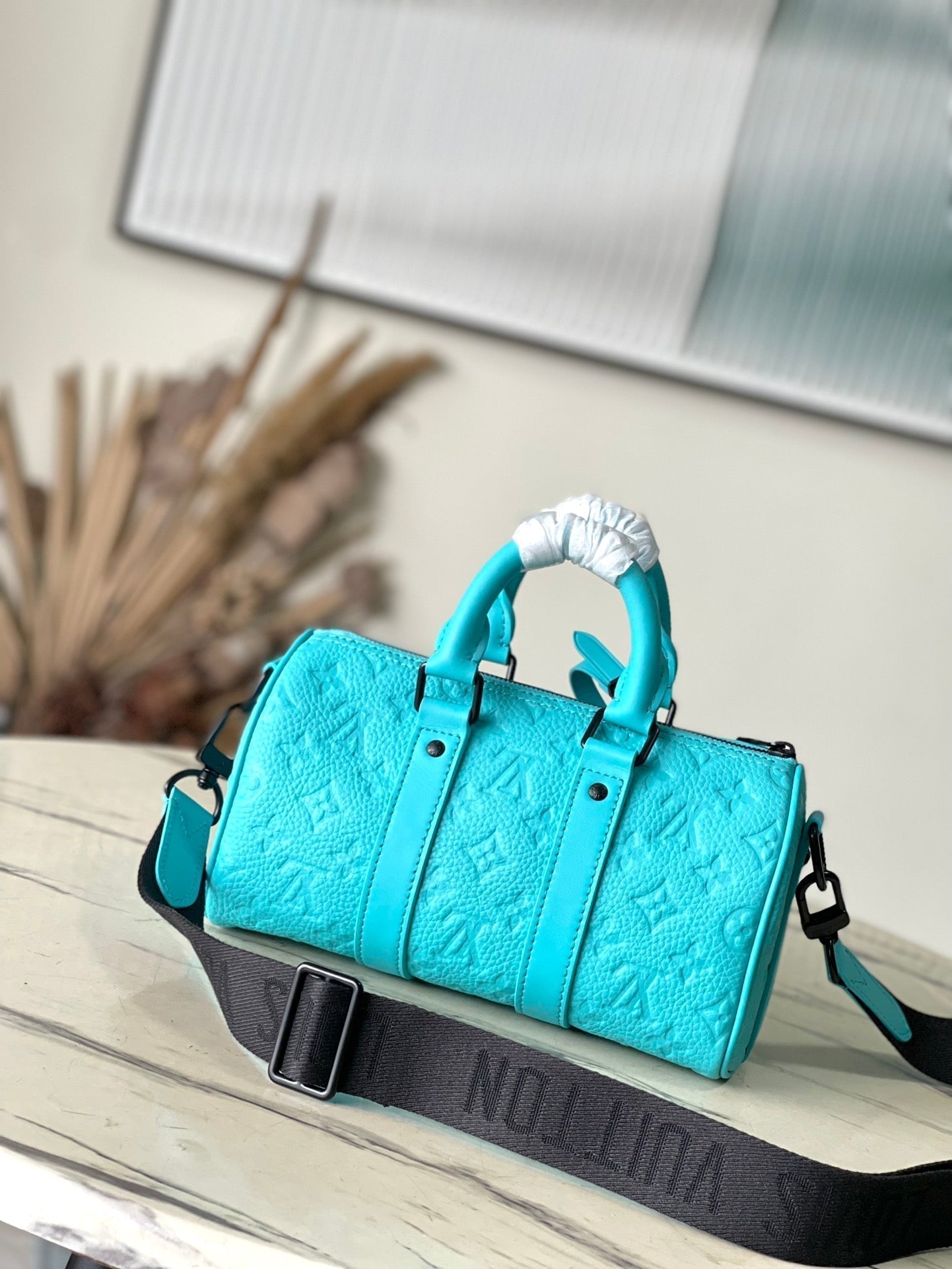 Sac bandoulière Keepall 25 en cuir de veau bleu turquoise monogrammé et embossé