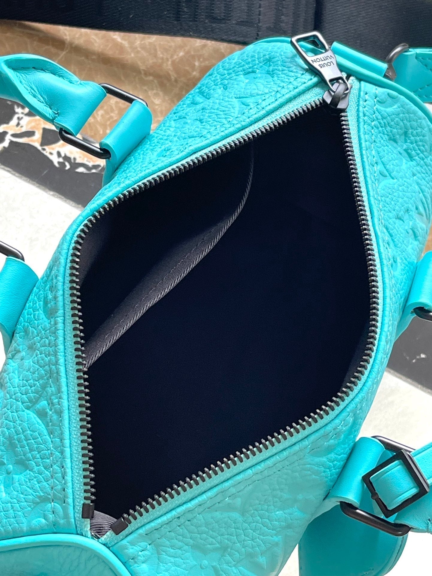 Sac bandoulière Keepall 25 en cuir de veau bleu turquoise monogrammé et embossé
